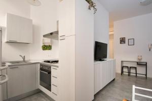 a kitchen with white cabinets and a tv in it at Casa Vacanze Il Campo in Siena