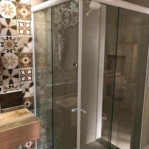 a shower with glass doors in a bathroom at Loft Caeté in Araruama