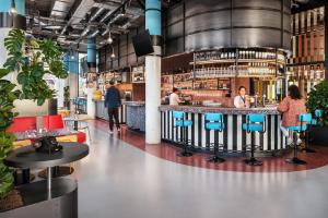 eine Bar in einem Restaurant mit Leuten, die dort sitzen in der Unterkunft The Social Hub Delft in Delft