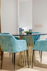 a dining table with blue chairs in a room at Hauzify I Apartamento Salamanca in Madrid