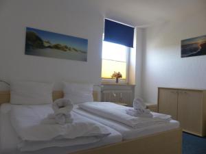una camera da letto con 2 asciugamani bianchi su un letto di Haus Uthlande Uthlande Whg 29 Weitblick a Wyk auf Föhr