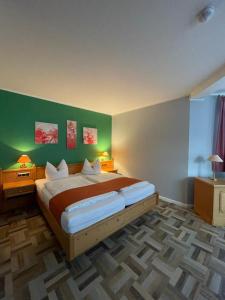 a bedroom with a large bed with green walls at Hotel & Restaurant Landgasthaus Zander in Blankenburg