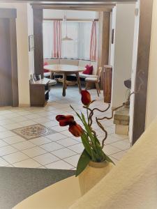 - un salon avec une table et un vase fleuri dans l'établissement Haus Schönblick, à San Lorenzo di Sebato