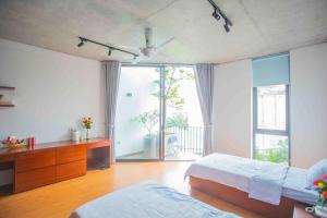 a bedroom with two beds and a large window at CRIN.HOUSE Homestay in Hanoi