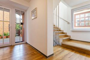 eine Treppe in einem Haus mit weißen Wänden und Holzböden in der Unterkunft Helgolandia Apartments in Helgoland