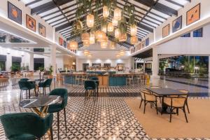 een lobby met tafels en stoelen en een bar bij Ocean Blue & Sand Beach Resort - All Inclusive in Punta Cana