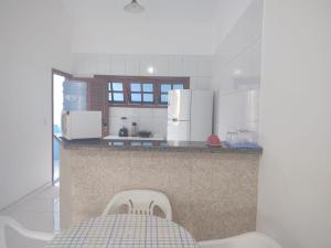 a kitchen with a counter with a chair in it at Apto em Porto Seguro - Centro in Porto Seguro