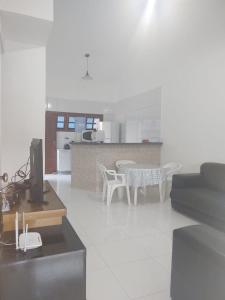 ein Wohnzimmer mit einer Küche und einem Tisch mit Stühlen in der Unterkunft Apto em Porto Seguro - Centro in Porto Seguro