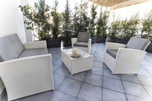 a patio with white wicker chairs and a table at Hotel Soleluna in Piano di Sorrento