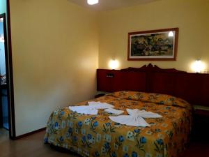 1 dormitorio con 1 cama con toallas en Pousada Sonnenhof, en Gramado