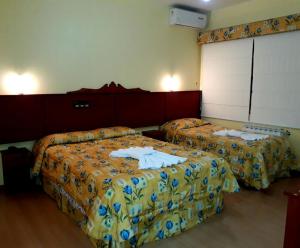 Habitación de hotel con 2 camas y toallas. en Pousada Sonnenhof, en Gramado