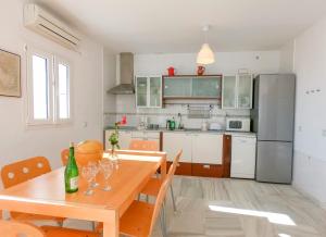 eine Küche mit einem Holztisch und einem Esszimmer in der Unterkunft Terraza Trafalgar Apartamento tipo penthouse con enorme terraza y vistas al mar in Conil de la Frontera