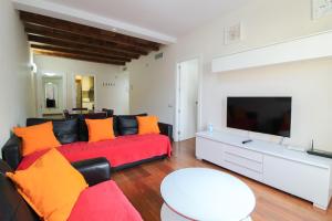 a living room with a red couch and a flat screen tv at Girona 108 in Barcelona