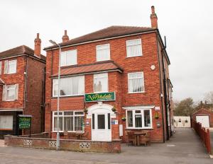 a red brick building with a sign on it at The Northdale Hotel Ltd in Skegness