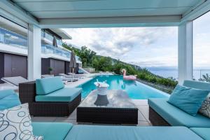 a swimming pool with blue chairs and a swimming pool at Stunning Kvarner Villa 5 Bedrooms Villa Aura Caesar Stunning Sea Views & Private Pool Opatija in Medveja