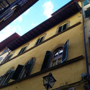 um edifício amarelo com janelas e uma luz de rua em Elisa Guest House em Florença