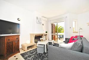 Il comprend un salon doté d'un canapé et d'une télévision à écran plat. dans l'établissement Apartment Capri by Algarve Vacation, à Albufeira