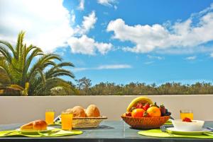 - une table avec des paniers de fruits et du pain sur un balcon dans l'établissement Apartment Capri by Algarve Vacation, à Albufeira