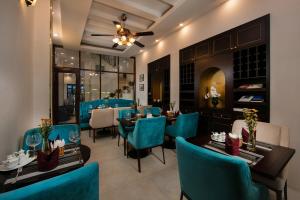 a dining room with blue chairs and tables in a restaurant at Labevie Hotel in Hanoi
