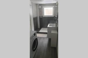 a bathroom with a washing machine and a sink at Appartement cosy proche du CHU in Rouen