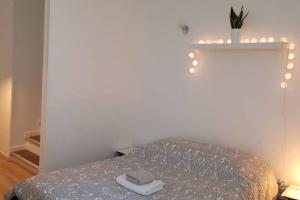 una camera da letto con un letto con luci sul muro di Appartement cosy proche du CHU a Rouen