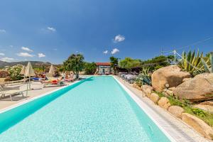 a pool at a resort with chairs and rocks at Residence Hotel Lu Nibareddu in San Teodoro