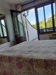 a bedroom with a bed and a window with a view at Gallardin Palace Hotel in Petrópolis