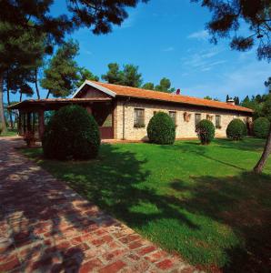 a brick house with bushes in front of a yard at Borgo San Antonio & Borgo San Giuseppe by La Principina in Principina Terra