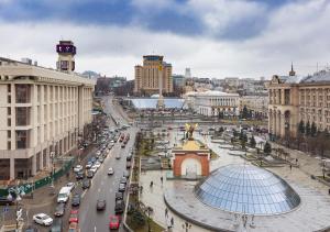 una città con una strada trafficata con auto e palazzi di Kozatskiy Hotel a Kiev