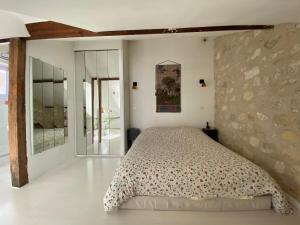 a bedroom with a bed and a stone wall at Appart'hôtel Paris Roland-Garros in Boulogne-Billancourt