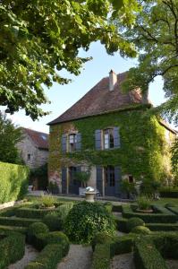 une maison couverte de lierre avec un jardin dans l'établissement Maison d'hôtes - Les Tillets, à Bois-Sainte-Marie