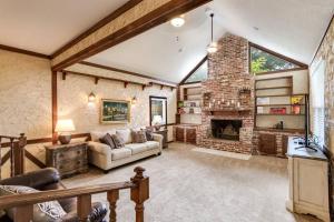 - un salon avec une cheminée en pierre et un canapé dans l'établissement English Cottage Pool Home Florida Style, à Orange Park