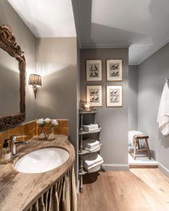 y baño con lavabo y espejo. en Guesthouse Dijver - Serene Escape in the Heart of Historic Bruges, en Brujas