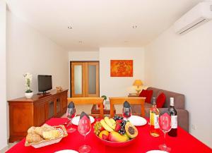 a table with a bowl of fruit and wine glasses at Apartment Caracas 2 by Algarve Vacation in Albufeira