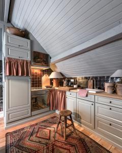 a kitchen with white cabinets and a wooden ceiling at Guesthouse Dijver - Serene Escape in the Heart of Historic Bruges in Bruges