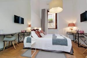 Schlafzimmer mit einem Bett, einem Schreibtisch und einem TV in der Unterkunft B&G Navona Apartment in Rom