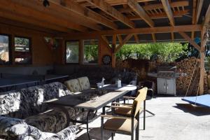 a patio with a table and chairs and a grill at Alpakatherapie und Ferienhof Charlottenthal in Charlottenthal
