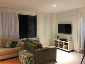 Il comprend un salon doté d'un canapé et d'une télévision à écran plat. dans l'établissement Quintas de Sauipe, Casa F7, à Costa do Sauipe