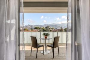 a table and chairs on a balcony with a view of mountains at Asso Residence Ospedale in Terni