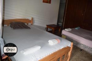 Casa Lucys Hostal في غرناطة: سريرين في غرفة عليها مناشف