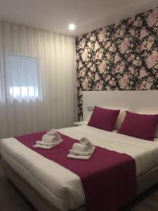 a bedroom with a large bed with towels on it at PinoyHouse Fatima in Fátima