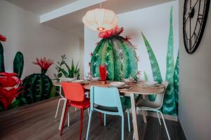una sala da pranzo con tavolo e sedie e un murale di cactus di ENJOY THE MOMENT Luxury La Tejita a La Tejita