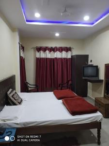 BalrāmpurにあるHotel Avadh Balrampurのベッドルーム1室(ベッド1台、テレビ付)