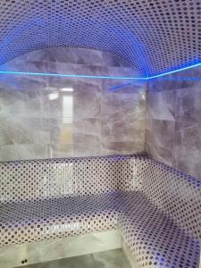 - une salle de bains pourvue d'une lumière bleue dans l'établissement Хотел АЛЕКСАНДЪР, à Pavel Banya