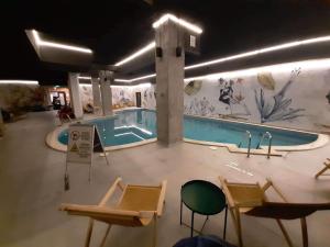 a pool in a building with chairs and a swimming pool at Flora Apartment 612A in Borovets