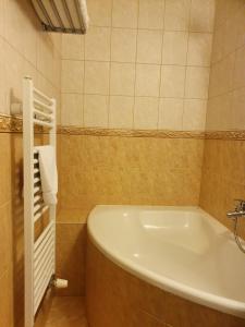ein Badezimmer mit einer Badewanne und einem Waschbecken in der Unterkunft Penzión Harmónia in Modra