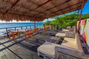 サンタ・マルタにあるGIO Hotel Tama Santa Martaのビーチ沿いのレストラン(テーブル、椅子付)