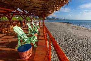 una fila de sillas sentadas en la playa en GIO Hotel Tama Santa Marta, en Santa Marta