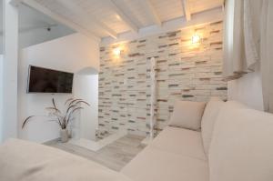 sypialnia z białą kanapą i kamienną ścianą w obiekcie Naxian Wave Seaside Villa w mieście Mikri Vigla