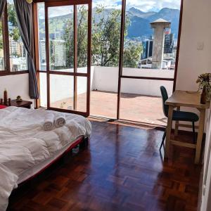 a bedroom with a bed and a table with a view at Play House in Quito